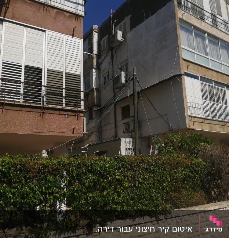 בניין עם סולמות ועבודות איטום על הקיר החיצוני